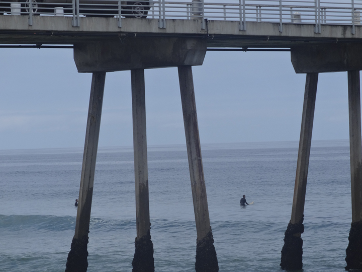 surfers-waiting-under-pier