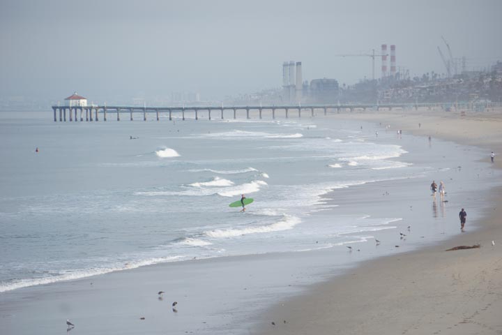 gray summer morning looking north to Manhattan Beach with surfers