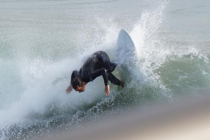 Huntington Beach surfer very close to pier
