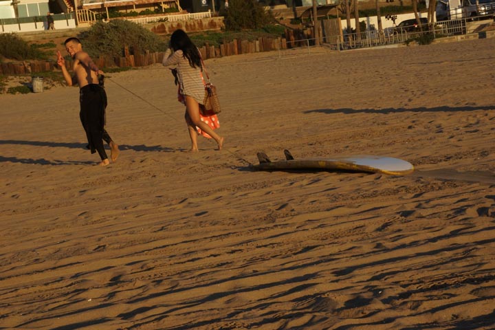 surfer-dragging-board-golden-hour-mb