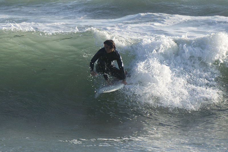 huntington-beach-surfer-grabbing-board-late-april